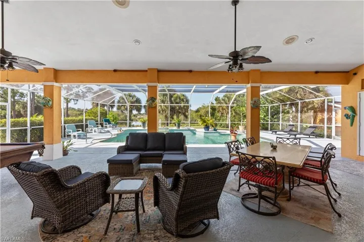 View of patio featuring glass enclosure, outdoor lounge area, and ceiling fan