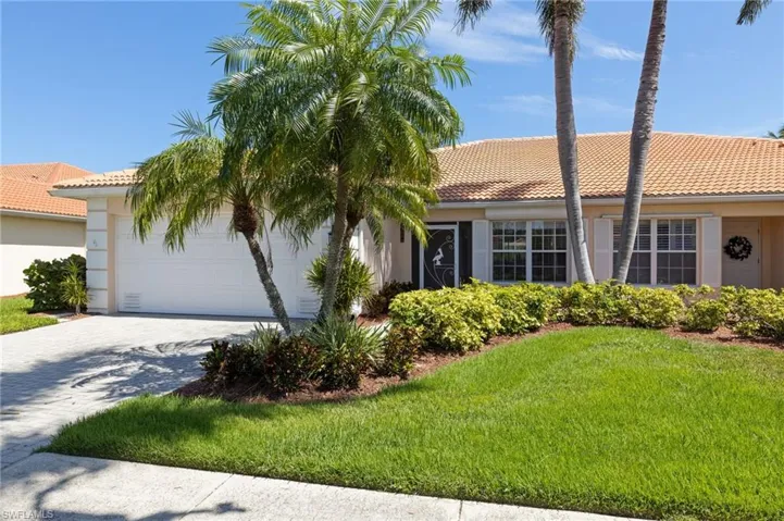 Mediterranean / spanish-style house with a garage and a front lawn