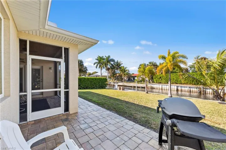 View of patio / terrace with a water view, a sunroom, and grilling area