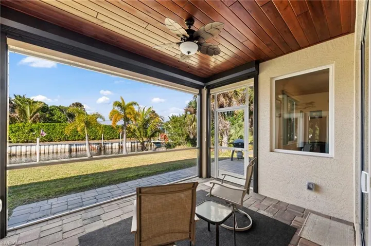 Sunroom / solarium featuring ceiling fan and a patio