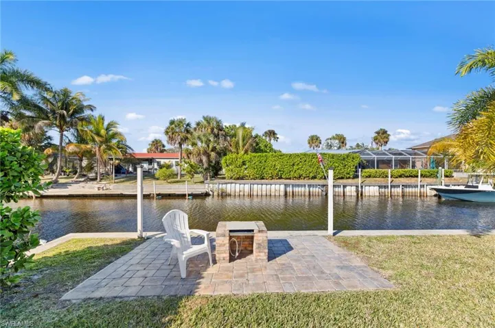 Dock featuring a water view, a lawn, and a patio area