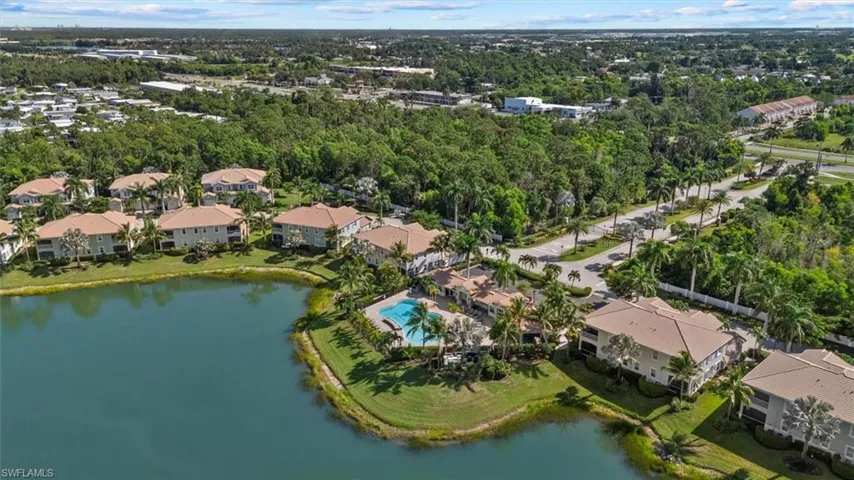 Waterfront property with multiple residential buildings, surrounded by mature trees and paved roads