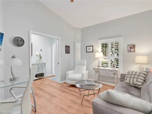 Living area featuring light wood-type flooring and vaulted ceiling