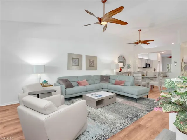 Living area with wood finished floors, a ceiling fan, recessed lighting, and lofted ceiling