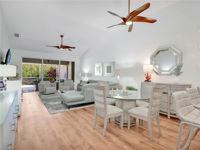 Dining room featuring lofted ceiling, ceiling fan, and light wood-type flooring