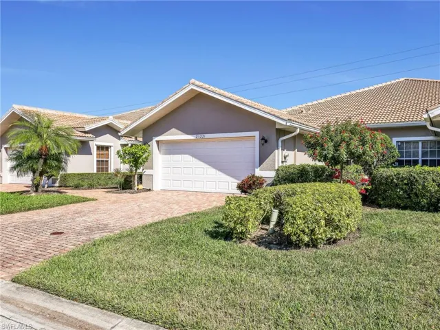 Single story home with stucco siding, decorative driveway, a front yard, and an attached garage