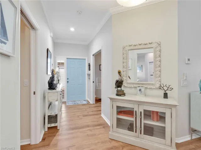 Hall featuring ornamental molding and light wood-style flooring