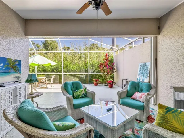 View of patio / terrace featuring a sunroom, outdoor lounge area, a ceiling fan, and a lanai
