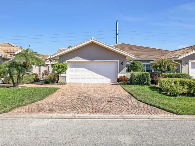 Ranch-style home with stucco siding, decorative driveway, a tiled roof, a garage, and a front lawn