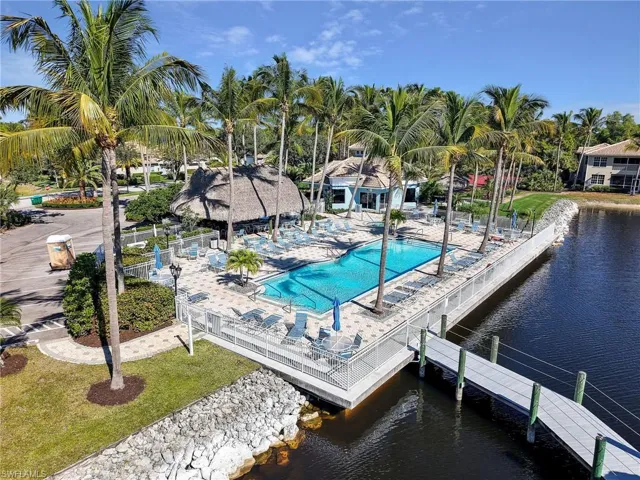Community pool with a water view, a lawn, and a patio area
