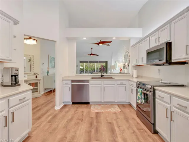 Kitchen with appliances with stainless steel finishes, white cabinetry, light wood finished floors, ceiling fan, and recessed lighting