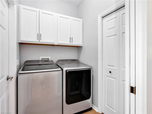 Laundry room with separate washer and dryer and cabinet space