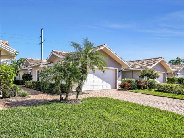 View of front of house with a tiled roof, a front lawn, and stucco siding