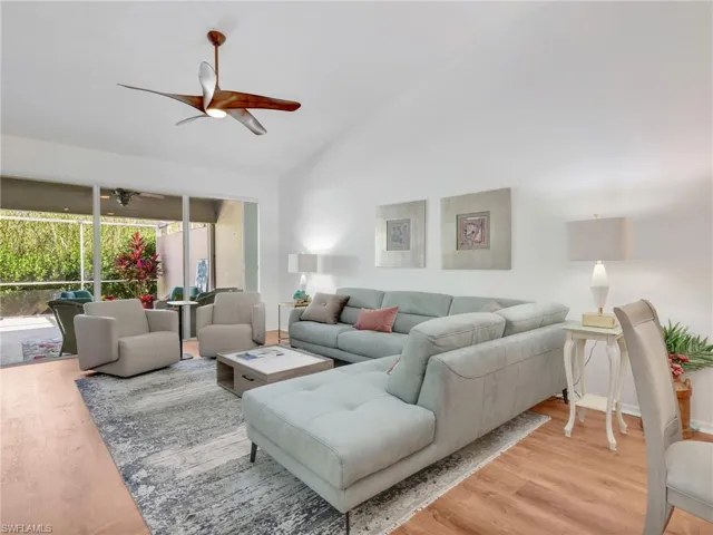 Living area with light wood-type flooring, ceiling fan, and lofted ceiling