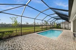 Outdoor pool with a sunroom, a lanai, and a patio