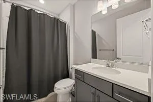 Bathroom with curtained shower and vanity