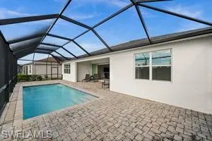 Swimming pool featuring a sunroom, a lanai, and a patio area