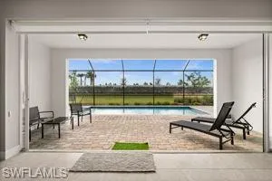 View of patio with an outdoor pool, a sunroom, and a lanai