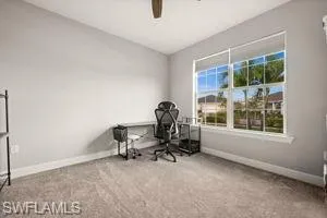 Office space with light carpet and a ceiling fan
