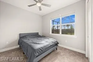 Carpeted bedroom with baseboards and a ceiling fan