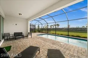 Outdoor pool featuring a patio area, glass enclosure, and a sunroom