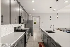 Kitchen with stainless steel appliances, pendant lighting, open floor plan, recessed lighting, and light tile patterned floors