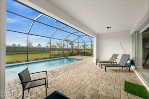 Outdoor pool with a patio, a sunroom, and glass enclosure