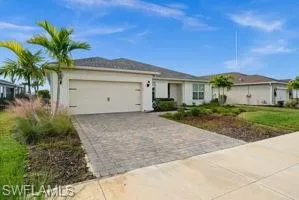 View of front of property featuring decorative driveway, a garage, and stucco siding