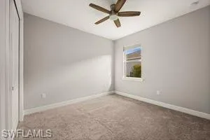 Unfurnished bedroom with a closet, carpet flooring, and a ceiling fan
