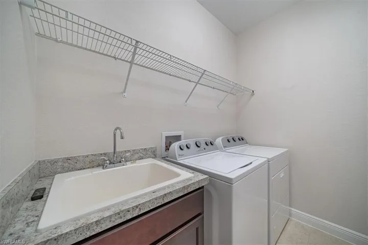 Laundry room featuring sink, washing machine and dryer, light tile flooring, and hookup for a washing machine