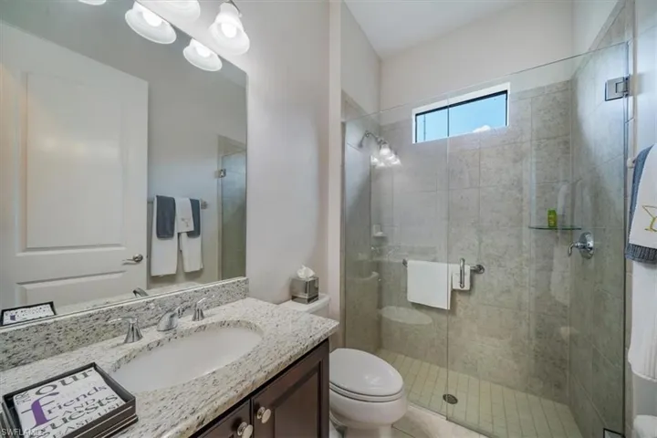 Bathroom featuring walk in shower, oversized vanity, and toilet