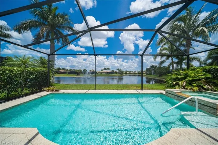 View of pool with glass enclosure and a water view