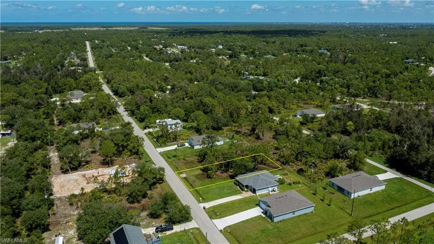 Aerial view of property's location with a heavily wooded area and property parcel outlined