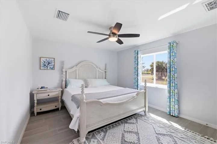 Bedroom with wood tiled floors and a ceiling fan
