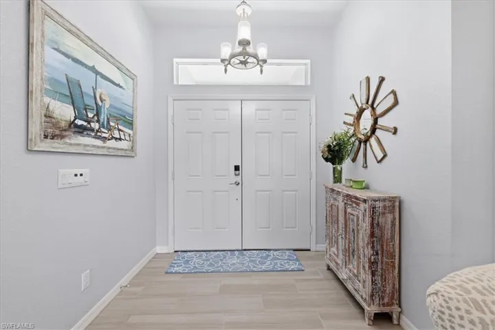 Foyer entrance with hanging lights and wood finish floors