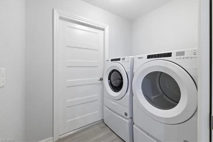 Laundry room featuring washing machine and dryer and light wood-style flooring