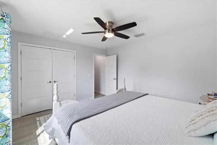Bedroom with ceiling fan, light wood-style flooring, and a closet