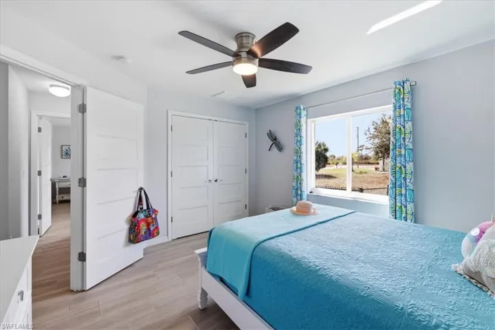 Bedroom with light wood finished floors, a closet, and ceiling fan