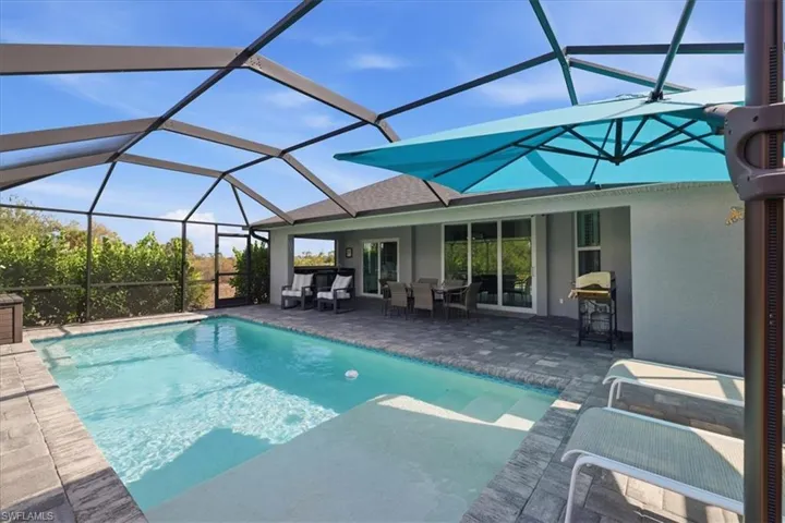 Swimming pool featuring a sunroom, a lanai, outdoor dining area, a patio area, and area for grilling