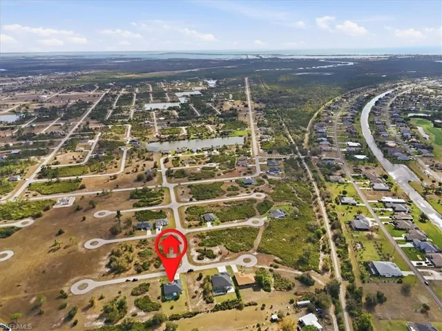Aerial overview of property's location with a large body of water and nearby suburban area