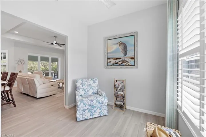 Living area featuring light wood finished floors, a ceiling fan, and recessed lighting