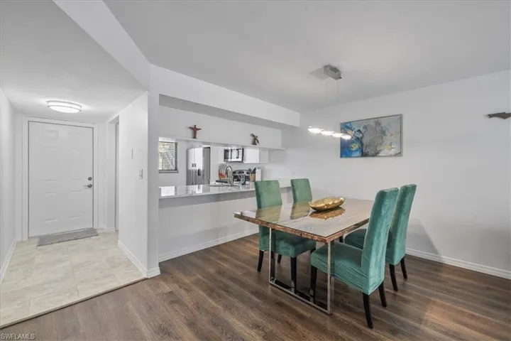 Dining room featuring dark wood-type flooring and baseboards