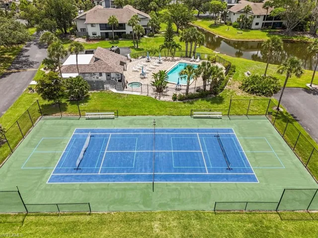 View of tennis court featuring a water view, a community pool, and a patio area