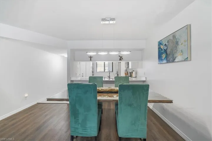 Dining area with dark wood-type flooring