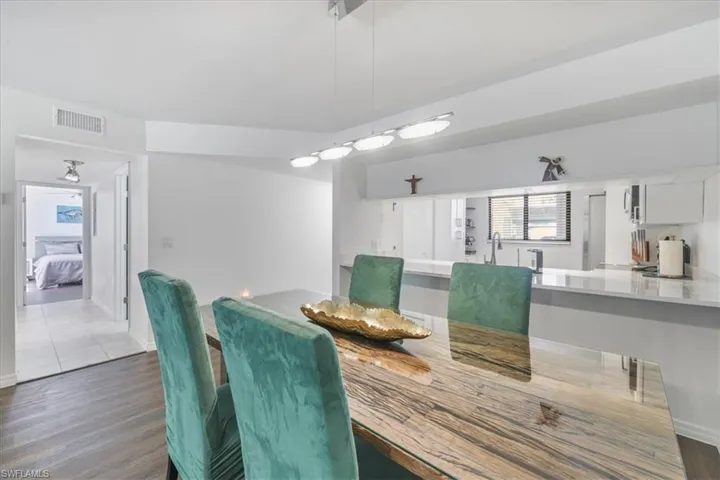 Dining room with dark wood finished floors and healthy amount of natural light