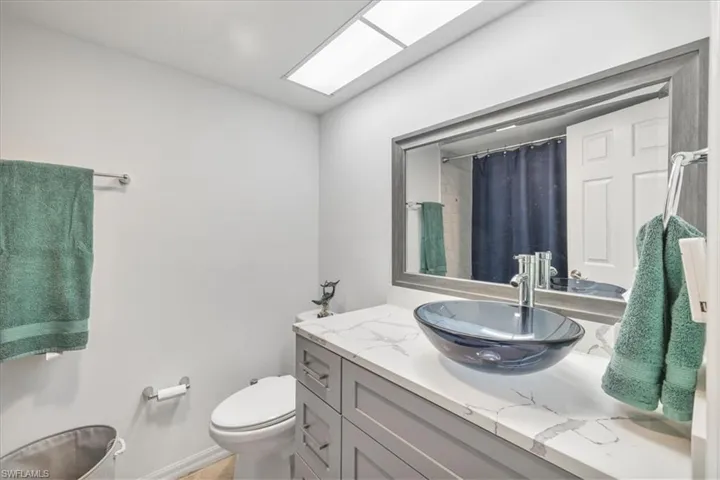 Full bath featuring curtained shower and vanity