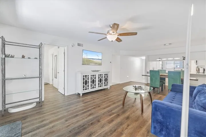 Living area with dark wood-style floors and a ceiling fan