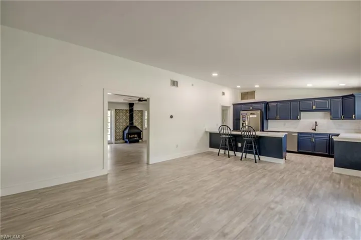 Kitchen featuring a kitchen breakfast bar, light countertops, stainless steel appliances, blue cabinetry, and light wood-style flooring