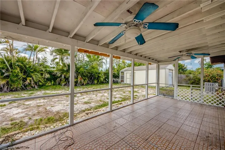 Unfurnished sunroom featuring a ceiling fan