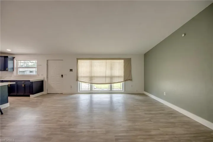 Unfurnished living room with light wood finished floors and baseboards
